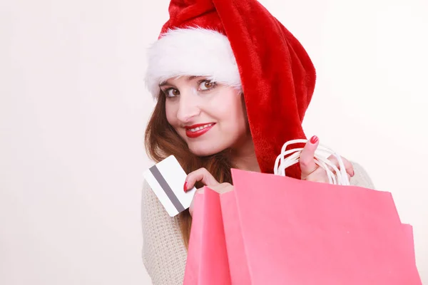 Mulher no chapéu de Natal detém cartão de crédito e sacos de compras . — Fotografia de Stock