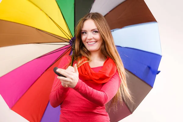 Frau steht unter buntem Regenschirm — Stockfoto