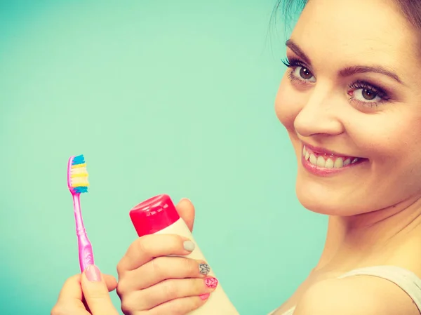 Mujer sostiene cepillo de dientes y pasta para la limpieza de dientes —  Fotos de Stock