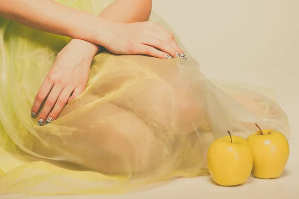 Mujer sentarse en vestido de luz verde con manzana . —  Fotos de Stock