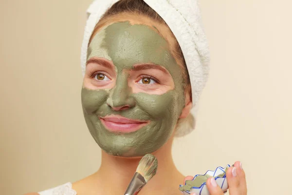 Femme appliquant avec un masque de boue d'argile brosse sur son visage — Photo