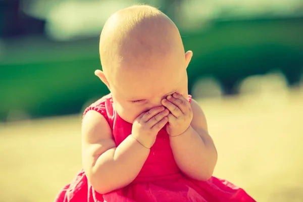 Pequeno bebê escondendo o rosto nas mãos — Fotografia de Stock