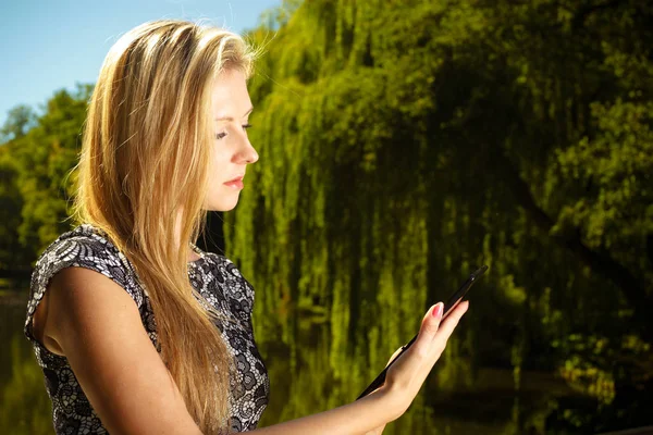 Vrouw zitten in park, het ontspannen en het gebruik van Tablet PC — Stockfoto