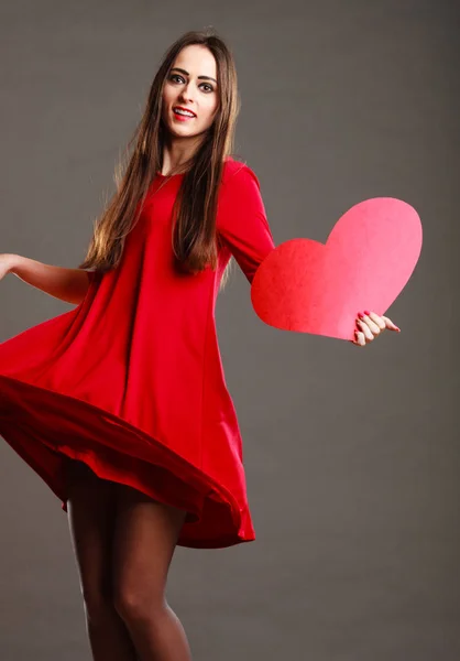 Mulher de vestido vermelho detém sinal de coração — Fotografia de Stock