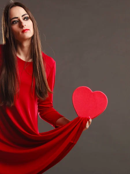 Kadın kırmızı elbise şeklinde kalp kutu tutar — Stok fotoğraf