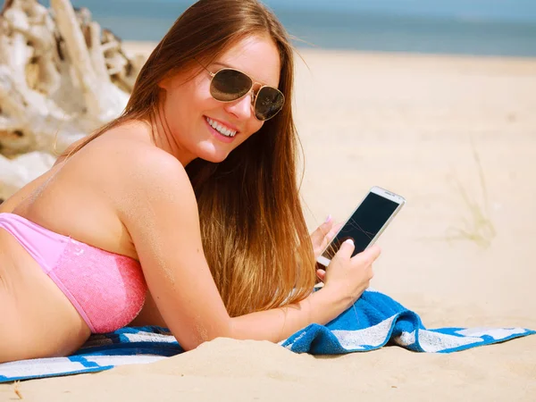 Mujer en la playa mensajes de texto en el teléfono inteligente . —  Fotos de Stock