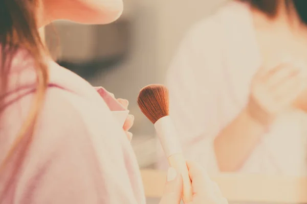 Mulher aplicando pó bronzeador com escova na pele — Fotografia de Stock