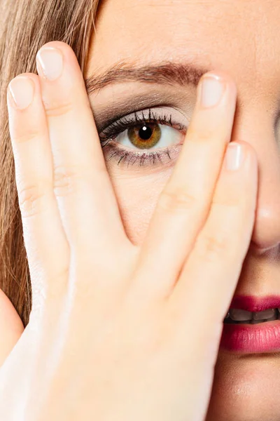 Kvinna täcka ansikte ser genom fingrarna. — Stockfoto