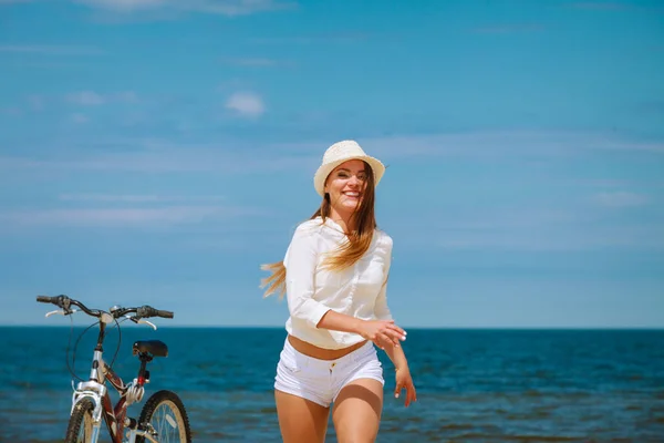 Flicka med cykel på stranden. — Stockfoto