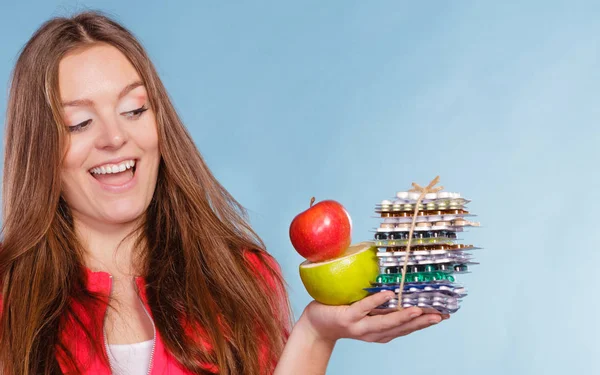 Woman holding pills and fruits. Health care — Stock Photo, Image