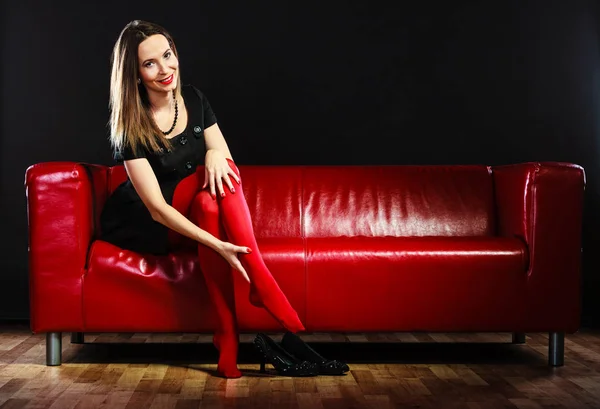 Fashion woman in red pantyhose on couch — Stock Photo, Image