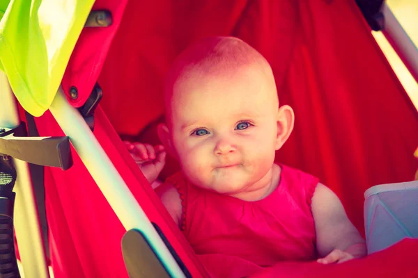 Wakker baby liggend in de wandelwagen met dummy — Stockfoto