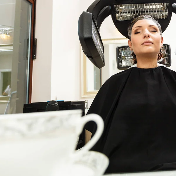 Mujer en peluquería, secando el cabello bajo la máquina — Foto de Stock