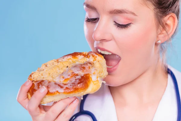 Dietitian eating sweet roll bun. Unhealth food. — Stock Photo, Image