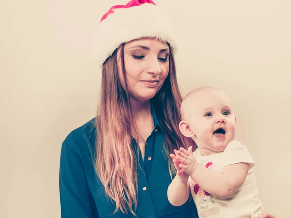 Matka noszenia santa hat gospodarstwa baby — Zdjęcie stockowe