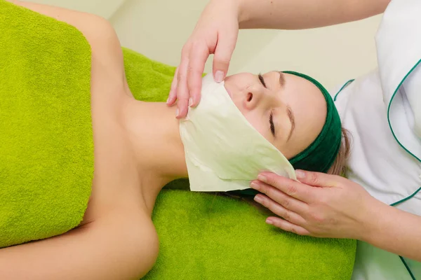 Esteticista limpiando máscara verde en la mujer — Foto de Stock