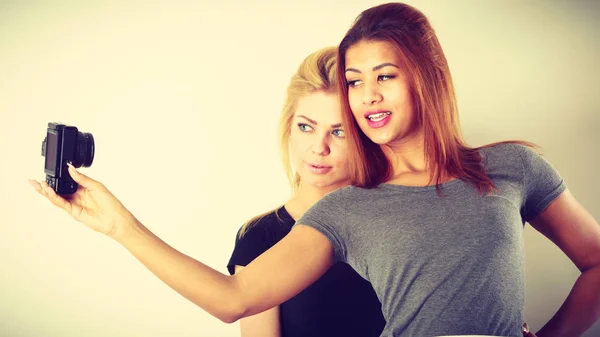 Two models girls taking self picture with camera — Stock Photo, Image