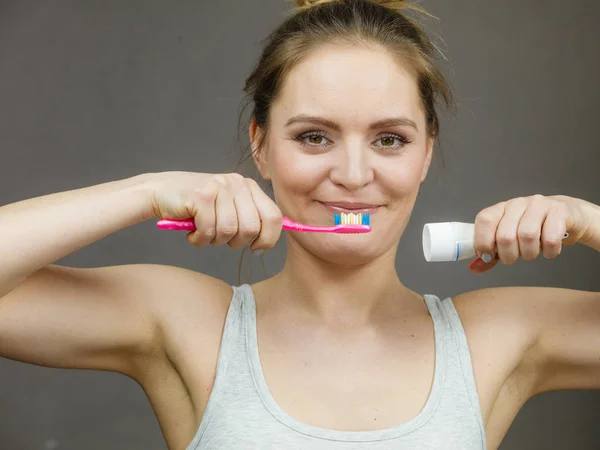 Mujer sosteniendo cepillo y pasta dental —  Fotos de Stock