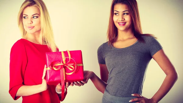 Dos hermosas mujeres con caja de regalo roja — Foto de Stock