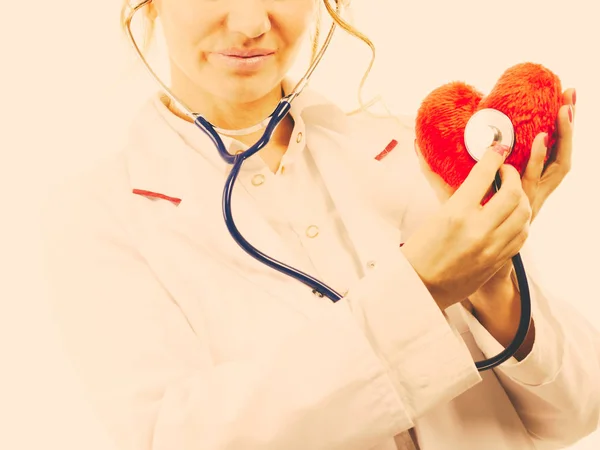 Arts met een stethoscoop onderzoeken rood hart. — Stockfoto