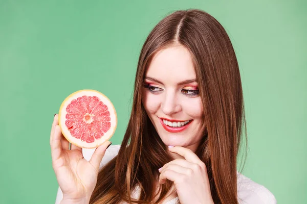 Mulher segura metade da fruta cítrica de toranja na mão — Fotografia de Stock