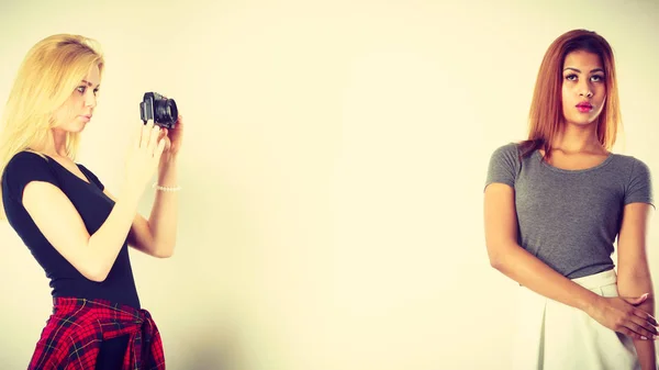 Blonde girl photographing mulatto woman — Stock Photo, Image