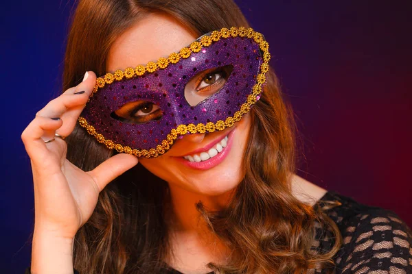 Closeup vrouw gezicht met carnaval violet masker op donker — Stockfoto