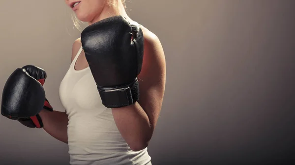 Ung kvinna armar bär boxning handskar. — Stockfoto