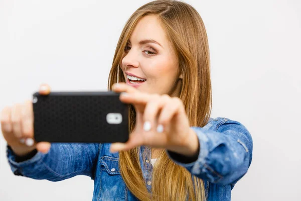 Woman in denim shirt taking self picture with phone — Stock Photo, Image