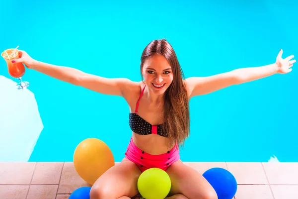 Szczęśliwa kobieta z balonów i koktajl przy basenie — Zdjęcie stockowe