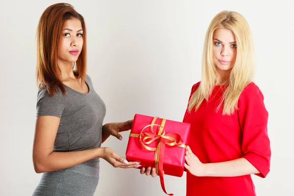 Dos hermosas mujeres con caja de regalo roja — Foto de Stock