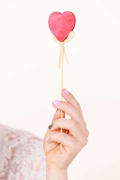 Woman holding heart shaped hand stick — Stock Photo, Image