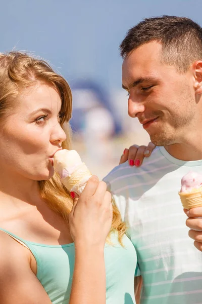 Mężczyzna i kobieta jedzący lody na plaży — Zdjęcie stockowe