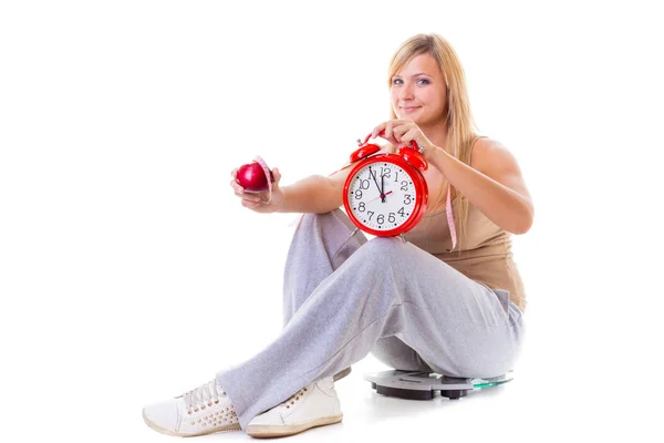 Kobieta trzyma jabłko, pomiaru taśmy i zegar — Zdjęcie stockowe