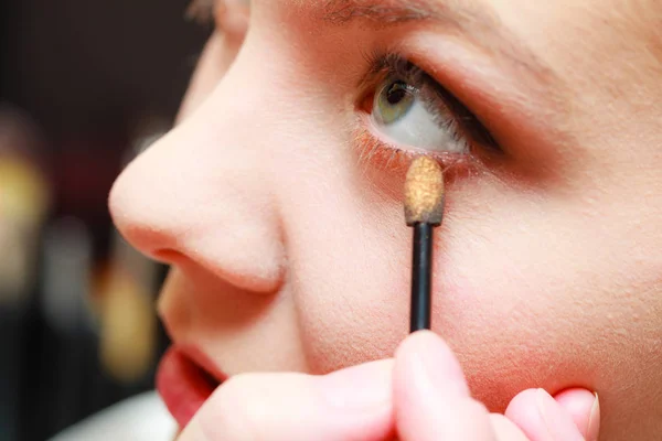 Fechar a mulher ficando maquiagem, sombra de olhos — Fotografia de Stock