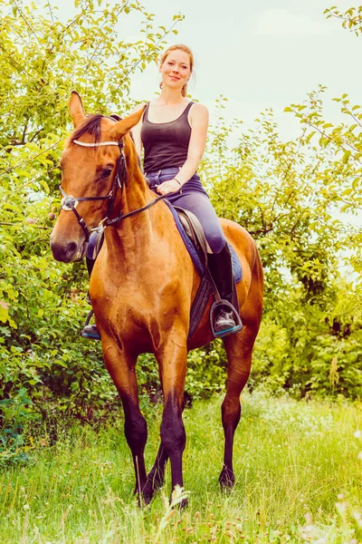 Mujer joven sentada en un caballo —  Fotos de Stock