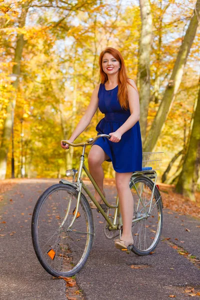 在公园里骑自行车的红发女士. — 图库照片