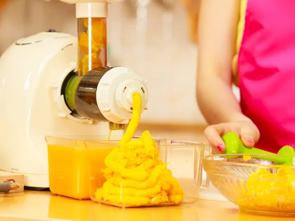 Mujer haciendo jugo de naranja en la máquina de juicer — Foto de Stock