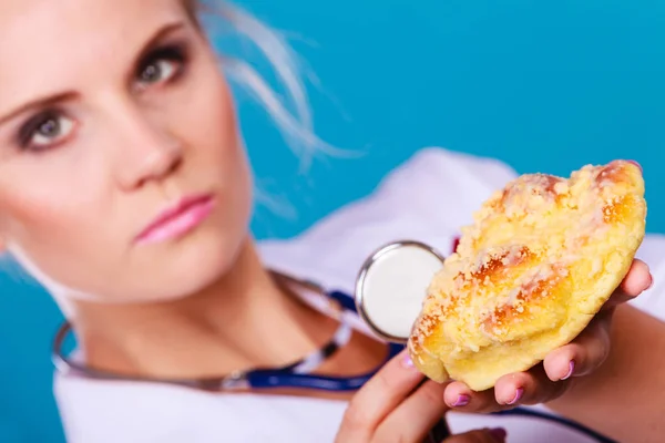 Ernährungsberaterin untersucht süße Brötchen mit Stethoskop — Stockfoto