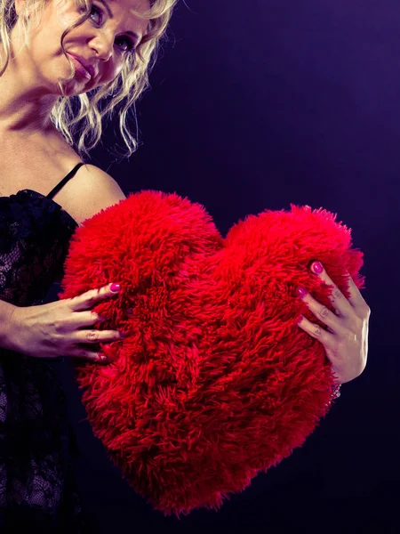Зрелая женщина обнимает большое красное сердце — стоковое фото