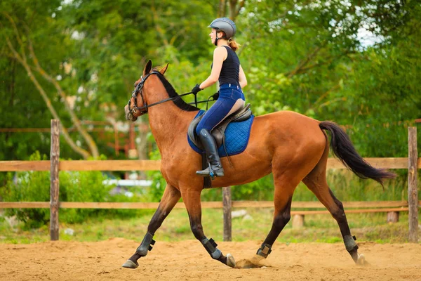 Jockey girl gör häst ridning på landsbygden äng — Stockfoto