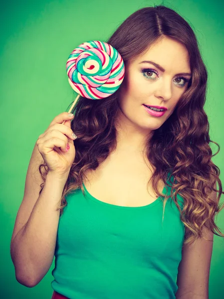 Smiling girl with lollipop candy on green — Stock Photo, Image