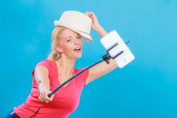 Femme prenant une photo d'elle-même avec téléphone sur bâton — Photo