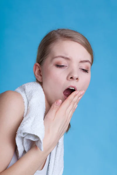 Mujer adormilada aburrida bostezando mientras sostiene la toalla — Foto de Stock