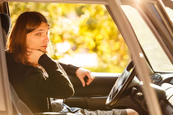 Aburrido joven con pelo largo coche de conducción — Foto de Stock