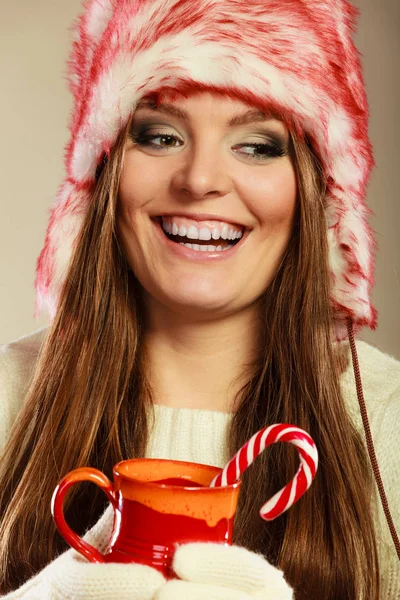 Kerstmis meisje met mok en suikerriet. — Stockfoto