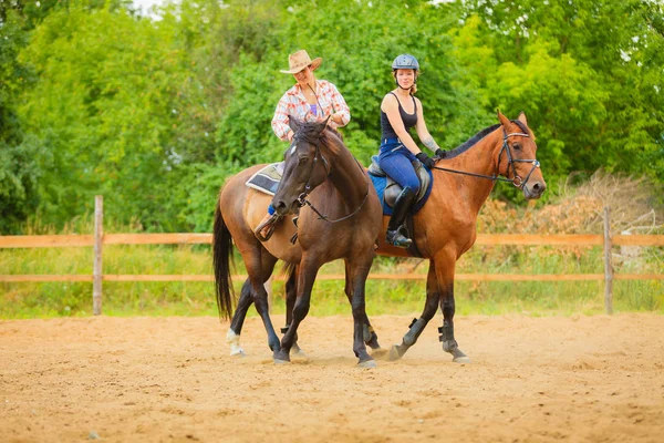 Cowgirl och kvinna jockey rider på hästar — Stockfoto