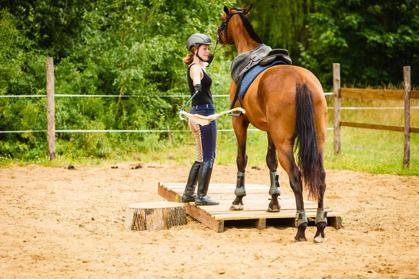 Jockey joven mujer consiguiendo caballo listo para montar — Foto de Stock