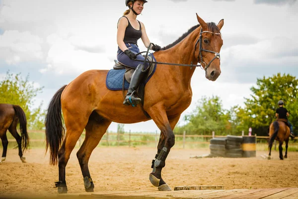 Jockey meisje doet paard rijden op platteland weide — Stockfoto