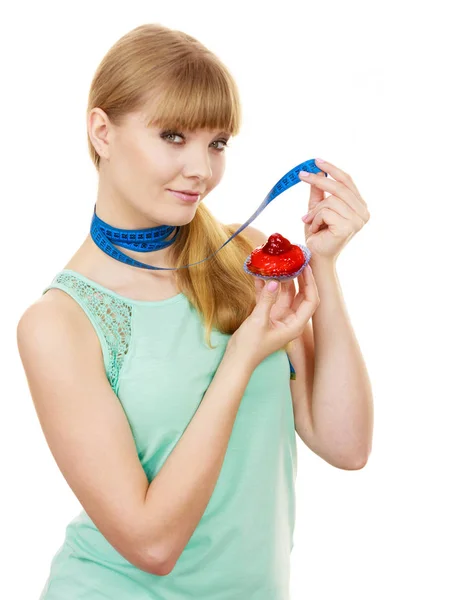 Woman holds cupcake and measuring tape. Diet — Stock Photo, Image
